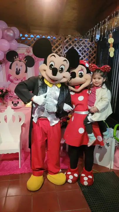 Mickey y Minnie con una niña en su cumpleaños