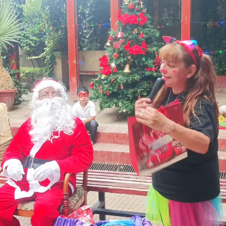 Viejito Pascuero con la animadora leyendo la carta en la fiesta de fin de año