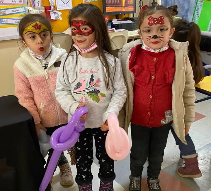 Tres niñas con pintacaritas y globos